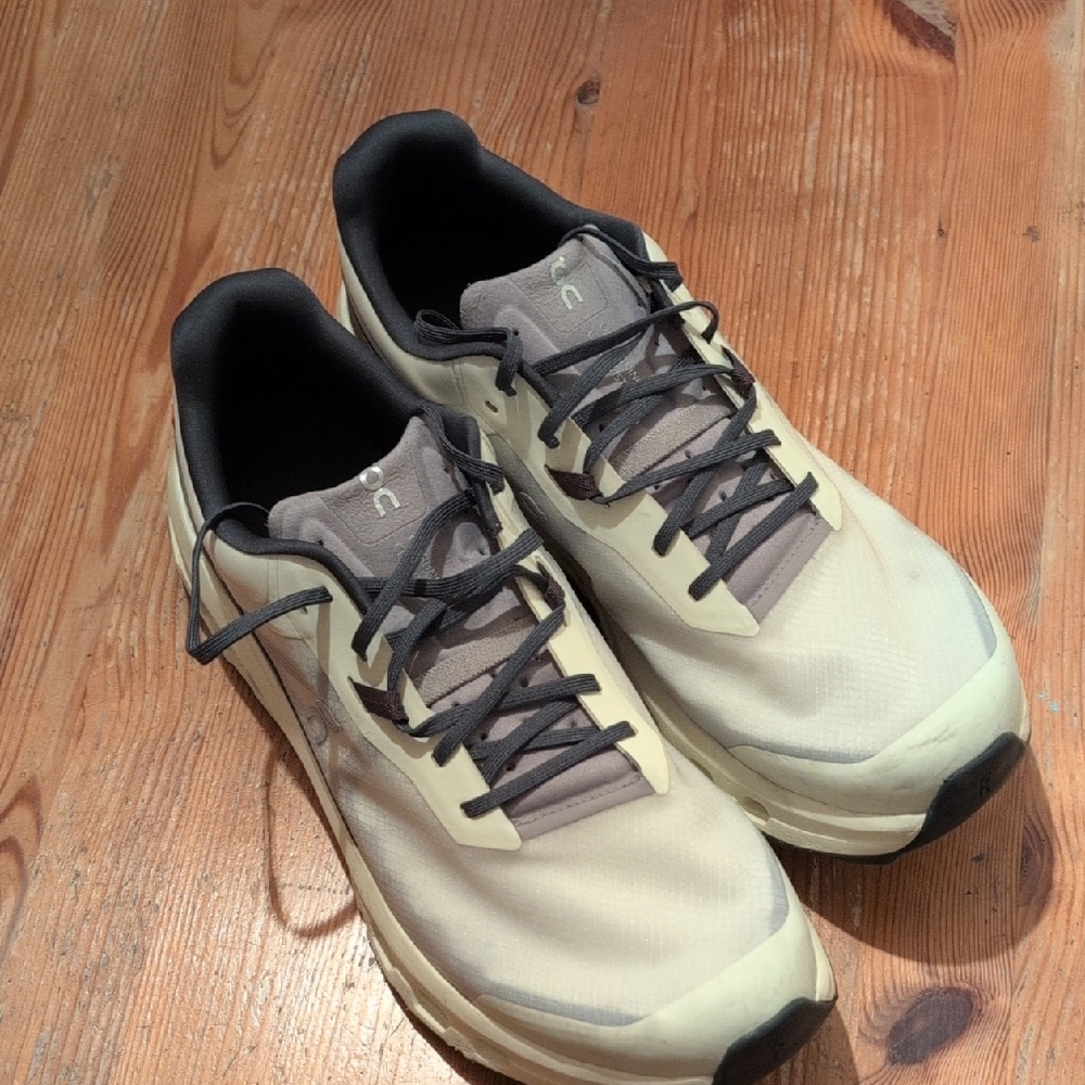 On Running Cream and Black Athletic Shoes